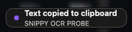 A small dark note in the corner of the screen: ‘Text copied to clipboard’, with the first line of the recognized text beneath it.